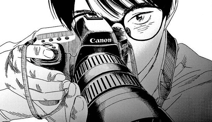 A photographer peering over the top of a camera.