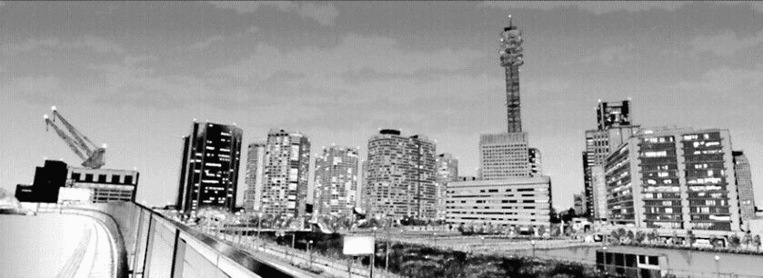 A city skyline seen from a highway overpass.